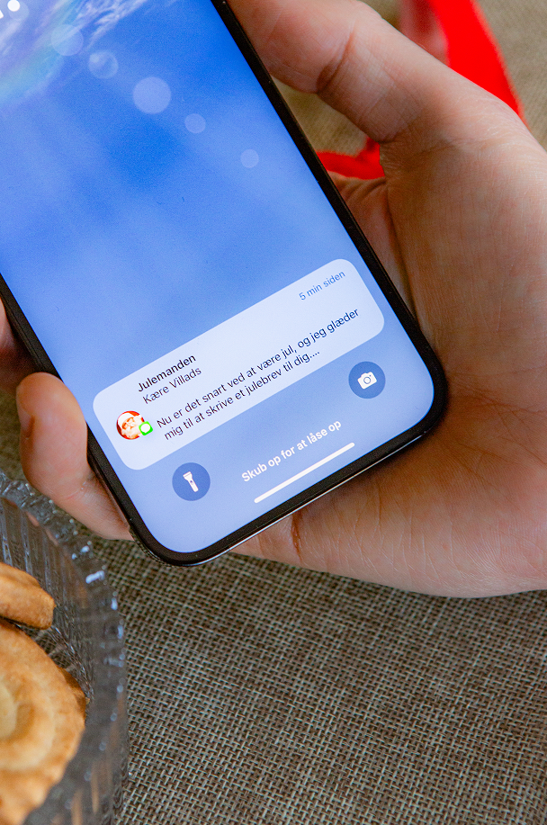 Et close up billede af far og søn som sidder og læser en julehistorie fra Julemandes Posthus