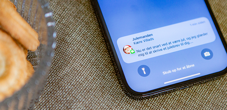 Et close up billede af far og søn som sidder og læser en julehistorie fra Julemandes Posthus